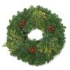 A festive wreath adorned with a mix of lush greenery, including various