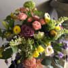 A hand-tied bouquet of freshly gathered flowers and lush foliage, ready to