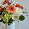 Our signature white milk glass vase is bursting with oranges, whites, peaches