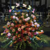 A LARGE ARRANGEMENT OF CALLA LILIES,ROSES AND ORCHIDS WITH AN ARCH OF