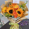 The product includes sunflowers, spray roses, daisies, gerbera daisies, and green leaves.