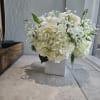 A timeless display of grace and sophistication, this all-white floral arrangement exudes