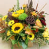 in a wooden box filled with fall array of flowers