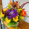 Fresh Mix of fall blooms designed in a clear cylinder vase.