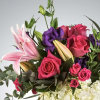 Bright pink roses and stargazer lilies come together with purple lisianthus and