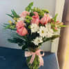 White Daisies, Pink Roses, Pink Alstroemerias and carnations, and greens. Clear vase.