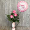 A cute pink and white floral arrangement inside of a ceramic ballet