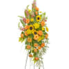 Standing funeral spray with bright yellows and oranges. 