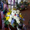 This cute arrangement is a pup in a basket made of flowers!