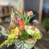 a beautiful fall display of flowers  to include orchids, ranunculus, protea