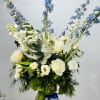 A blue and white arrangement featuring roses, tulips, and delphinium. Send this
