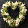 Elegant white floral open heart accented by green orchids expresses sympathy and