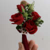 Orchid or rose boutonniere include seasonal greens, and a ribbon in the