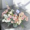 A soft and refreshing arrangement of seasonal blooms in blush and cream
