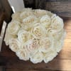 Twenty-four beautiful roses arranged in a clear glass vase. A classic and