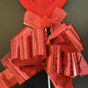 A decorative plush heart on a stick with sparkling red ribbon details.