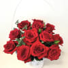 A large tall handled basket filled with one dozen premium red roses