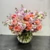 This charming arrangement features lush peach garden roses paired with delicate pink