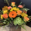Fall flowers in a rustic wooden planter. Features orange roses, fall mums