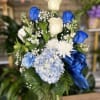 fresh blue and white flowers in vase with blue ribbon 