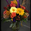 A bright, colorful mix of fall seasonal flowers arranged in a sleek