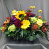 A beautiful mixture of fall assorted flowers arranged in a rustic wooden