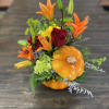 Beautiful ceramic pumpkin vase with red roses and an array of fall