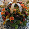 Rustic tin Pumpkin in the center of a whimsical fall arrangement in