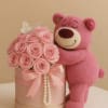 Oso de peluche abrazando una caja de rosas, del color de su