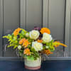 A charming seasonal arrangement that captures the essence of autumn&#039;s warm hues