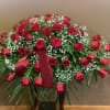 Red Roses with accents of Baby&#039;s Breath arranged with foliage for a
