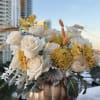 Creamy white roses and golden accents intertwine with natural wheat in a