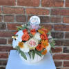 A gorgeous arrangement of blush pink roses, butterscotch mums, orange spray roses