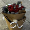 Beautiful bouquet of red or white roses wrapped in paper, accented with