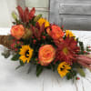 A cornucopia filled with an abundance of lilies, chrysanthemums, roses, sunflowers, and