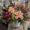 A lovely seasonal look that includes roses, hydrangea, orchids, and a succulent.