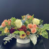 This floral arrangement comes in a beautiful ceramic bowl with leaves and
