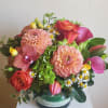 Bright arrangement with green hydrangea, bright orange/ or hot pink roses, dahlias