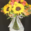 Bursting with cheer, this radiant arrangement combines golden sunflower, orange roses, and
