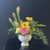 Roses and carnations nestled under gerberas and tulips.  In a ceramic
