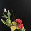 Roses and carnations nestled under gerberas and tulips.  In a ceramic