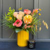 A seasonal gift set including a fall arrangement and a 9.5 oz