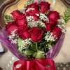 A gorgeous gathering of 1 dozen roses with filler, greens, and a