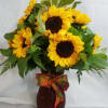 Gorgeous sunflowers in a tall fall coloured glass vase.