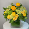 This arrangement bursts with sunny yellow ranunculus and roses, paired with fresh