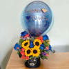 This stunning arrangement features bright sunflowers, blue roses, orange gerberas, and other