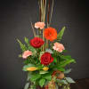 This tall standing arrangement is a noble tribute to autumn. Featuring red