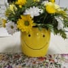 Ceramic smiley face container with yellow and white daisies and yellow/white carnations