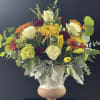 Beautiful Eggshell ceramic vase filled with fall blooms and greenery.