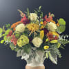 Beautiful Eggshell ceramic vase filled with fall blooms and greenery.